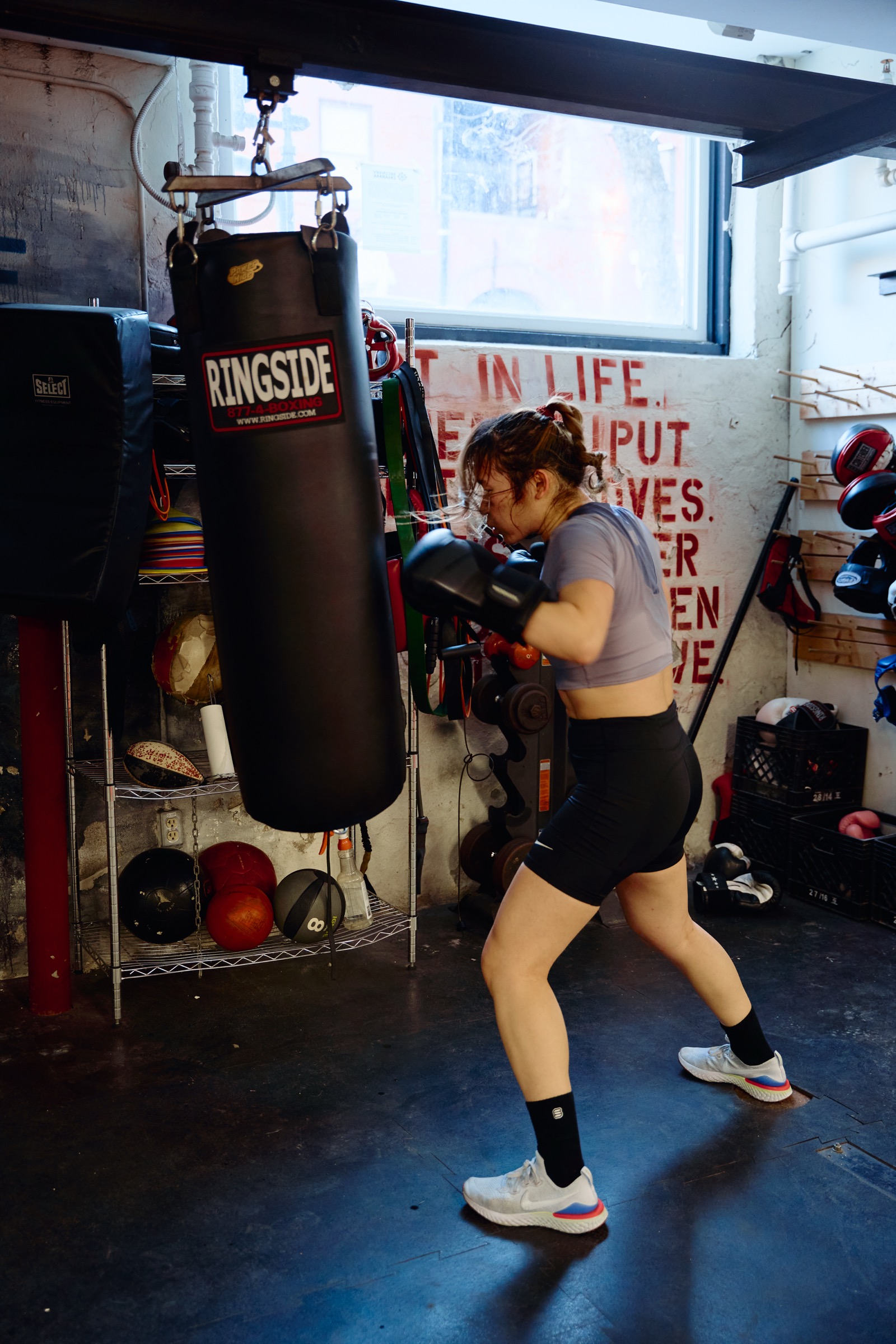 Woman hitting the heavy bag at Pan Am Boxing Club